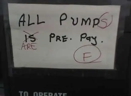 Sign on gas station pump reads "All Pump is pre. pay." It has been marked with red pen to correct mistakes such as adding an "s" to Pump and scratching out "Is" to replace with "are" and then grading it F.