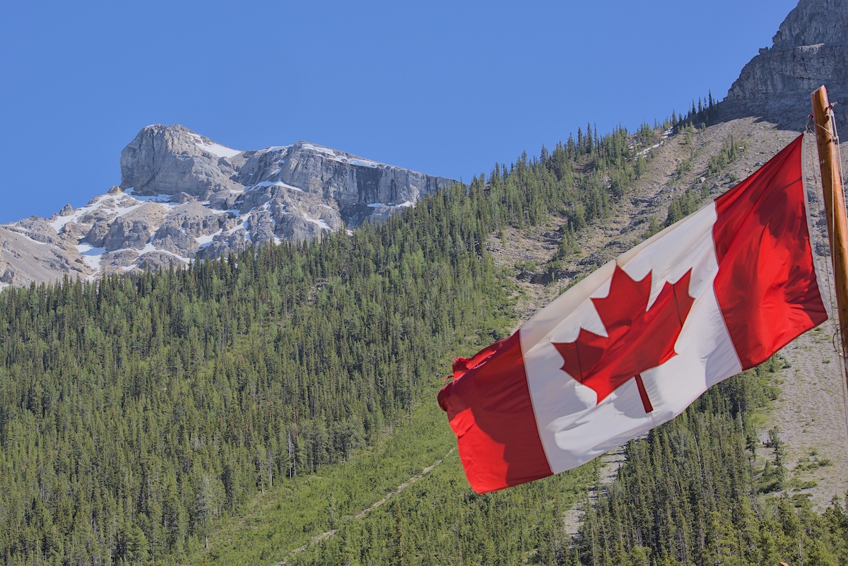 The Canadian flag waves in the wind in front of Eagle Mountain at the start of the Healy Pass/Egypt Lake trail.